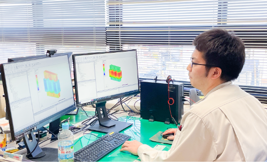 画像：コンピューターに向かい仕事に没頭する社員